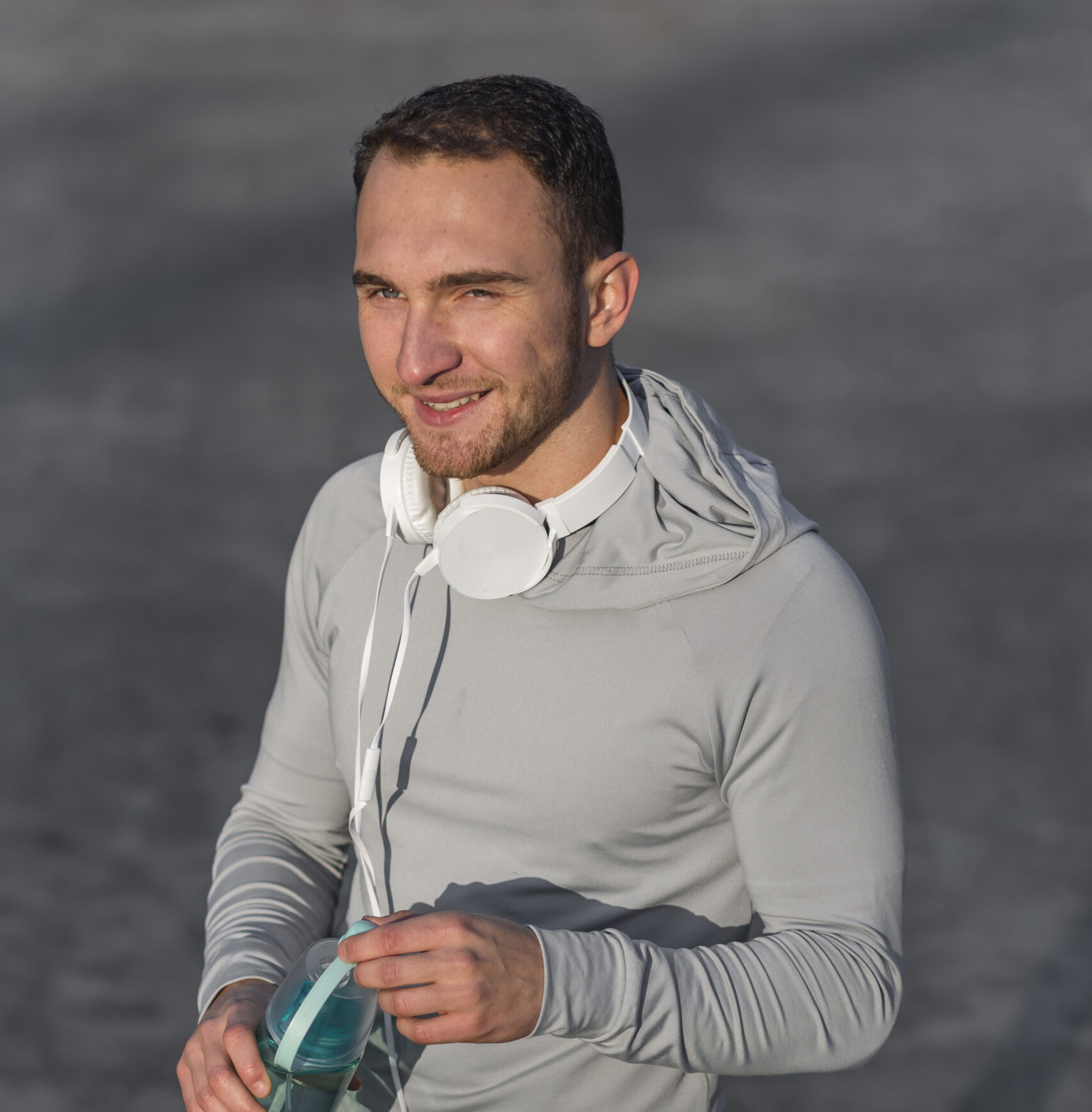 smiling-sporty-man-holding-bottle-water